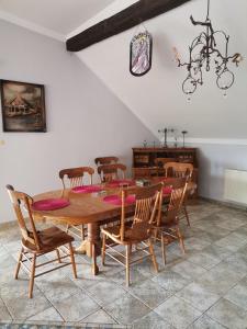 a dining room with a wooden table and chairs at Pod Jesionem in Rachanie