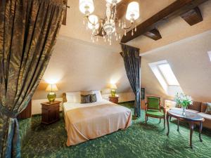 タタにあるPlatan Udvarhazのベッドとシャンデリアが備わるホテルルームです。
