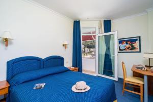 Boutique & Beach Hotel Villa Wolff في دوبروفنيك: غرفة نوم بسرير ازرق وعليه قبعة