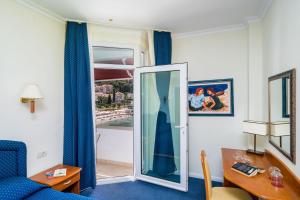 a room with a blue couch and a glass door at Boutique & Beach Hotel Villa Wolff in Dubrovnik