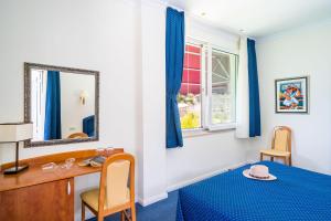 a bedroom with a desk and a mirror at Boutique & Beach Hotel Villa Wolff in Dubrovnik
