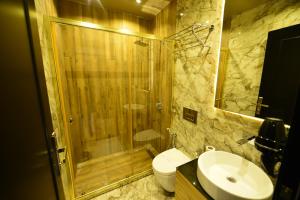 La salle de bains est pourvue d'une douche, de toilettes et d'un lavabo. dans l'établissement Inanlar Deluxe Hotel & Bungalow, à Uzungöl