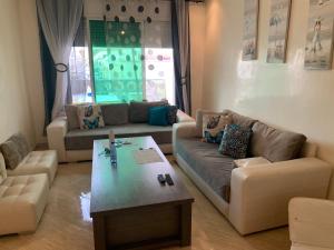 a living room with two couches and a coffee table at A 5 minutes à pied de la plage un bel appartement à saisir in Sidi Rahal +3 photos