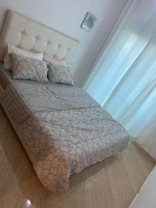 a bedroom with a bed with a white headboard at A 5 minutes à pied de la plage un bel appartement à saisir in Sidi Rahal