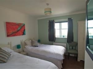 a bedroom with two beds and a window at Jurassic Apartments in Weymouth