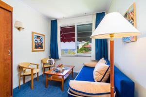 a living room with a blue carpet and a table at Boutique & Beach Hotel Villa Wolff in Dubrovnik +43 photos