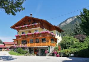a large house with flowers on the balcony at Wagnerhof in Pichl bei Aussee