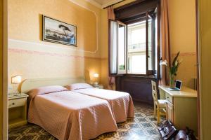 a bedroom with a bed and a window at Hotel Fiorita in Florence
