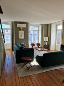 ポルトにあるCondes de Azevedo Palace Apartmentsのリビングルーム(緑のソファ、テーブル付)