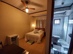 1 dormitorio con 1 cama y ventilador de techo en Pousada Girar do Sol en Nova Friburgo