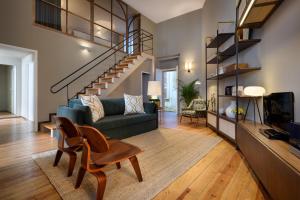 a living room with a couch and a staircase at Condes de Azevedo Palace Apartments in Porto