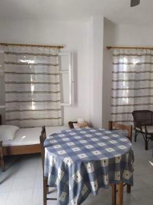 a bedroom with a bed and a table and window at Stamoulis Apartments in Kámpos