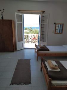 a room with two beds and a door with a patio at Stamoulis Apartments in Kámpos