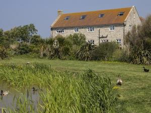 a house with ducks in the water in front of it at Swallows Rest in Weymouth