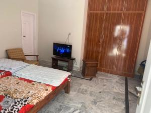 a bedroom with a bed and a tv in it at Shah Family Guest House in Swat