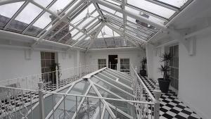 a room with a glass ceiling and a staircase at Netley Hall in Shrewsbury