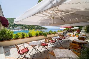 a patio with tables and chairs with a view of the water at Boutique & Beach Hotel Villa Wolff in Dubrovnik