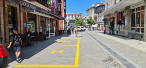 a man walking down a street with a yellow line on the sidewalk at Gran Hotel Paraiso in Llanes