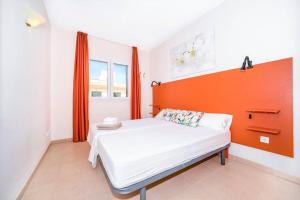 a bedroom with an orange headboard and a white bed at Residence El Paraiso in Sa Ràpita +16 photos