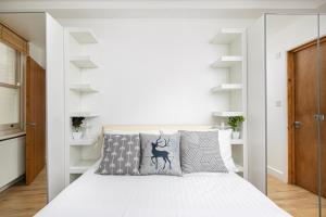 a bedroom with a white bed with grey pillows at Skyvillion - One Bedroom Apartment by London King's Cross in London