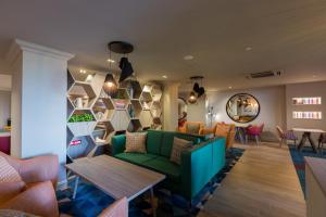 a lobby with a green couch and a table at Holiday Inn - Glasgow Airport by IHG in Paisley