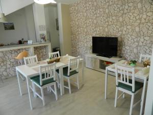 uma sala de jantar com mesa e cadeiras e uma televisão em A Casa di Anna - Locazione Turistica - em Matera