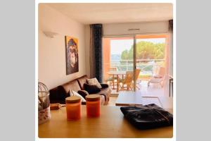 a living room with a couch and a table at Appartement VAIANA avec piscine en bord de mer in Ajaccio