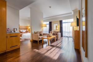 Sala de estar con sofá, cama y mesa en Ramada Addis, Addis Ababa en Addis Abeba