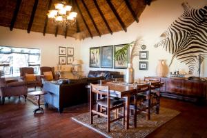 a living room with a table and chairs and a couch at Umkumbe Safari Lodge Riverside in Skukuza