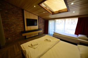 Cette chambre comprend 2 lits et une télévision. dans l'établissement Inanlar Deluxe Hotel & Bungalow, à Uzungöl