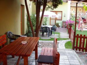 una mesa de madera y sillas en un patio con sombrilla en Penzion Orion Hovorany, en Hovorany