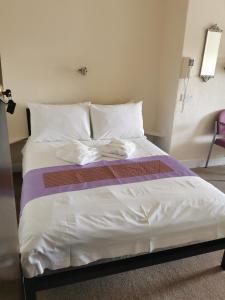 1 cama grande con sábanas y almohadas blancas en Westleigh, en Morecambe