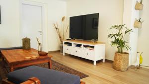 una sala de estar con TV en un armario blanco en בין האלונים, en H̱arashim