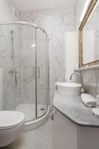 een badkamer met een douche, een toilet en een wastafel bij Apartments ART TEATRO in Rijeka +28 foto's