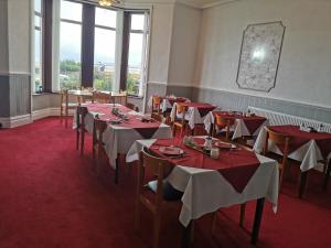 a dining room with red and white tables and chairs at Westleigh B&B in Morecambe