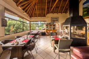 a restaurant with tables and chairs and a fireplace at Winelands Villa Guesthouse and Cottages in Somerset West