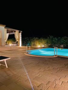 an empty swimming pool at night at Villa Melissa in Tertenìa