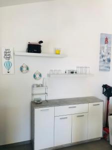 a kitchen with white cabinets and a counter at Villa Melissa in Tertenìa +6 photos