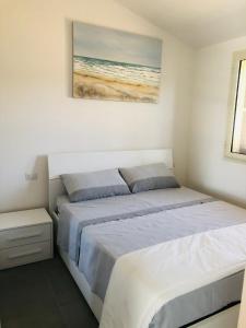 a bedroom with a bed and a painting on the wall at Villa Melissa in Tertenìa