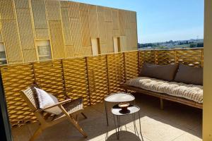 a balcony with a couch and a chair and a table at Nouveau ! DoraMar : standing entre ville et mer in Montpellier