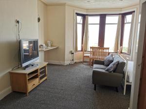 a living room with a couch and a tv at Westleigh B&B in Morecambe