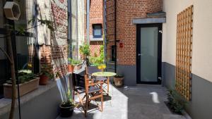 - une petite terrasse avec une table et des chaises en face d'un bâtiment dans l'établissement Duplex in historical centre with private courtyard, à Anvers