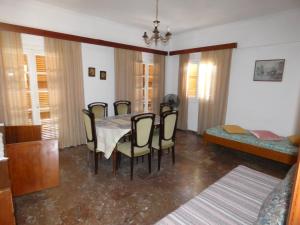 a dining room with a table and chairs and a bed at Iona Achilleion Appartments in Achílleion
