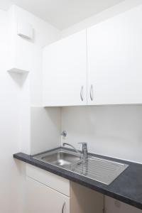 a kitchen with a sink and white cabinets at Leben im Herzen von Fulda in Fulda