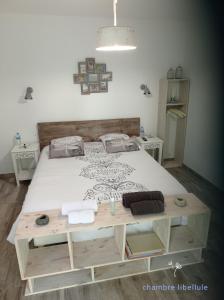 1 dormitorio con cama y mesa de madera en les chambres du pont des chèvres, en Commensacq
