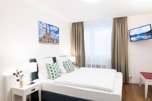 a hotel room with a white bed and a window at Leben im Herzen von Fulda in Fulda