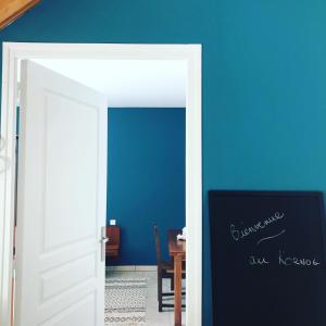 una puerta abierta en una habitación con una pared azul en Domaine des Pins, en Cast