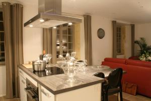 a kitchen with a table with wine glasses on it at Le Porche de Sarlat in Sarlat-la-Can&eacute;da