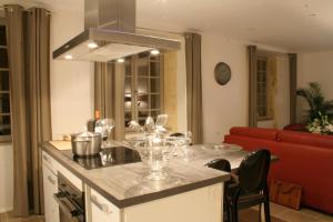 una cocina con una mesa con copas de vino. en Le Porche de Sarlat, en Sarlat-la-Canéda