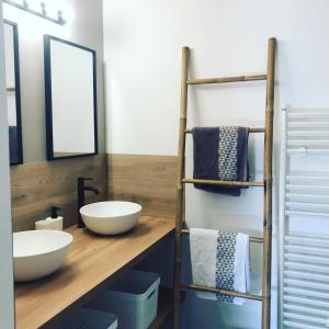 a bathroom with a counter with two sinks and mirrors at Domaine des Pins in Cast